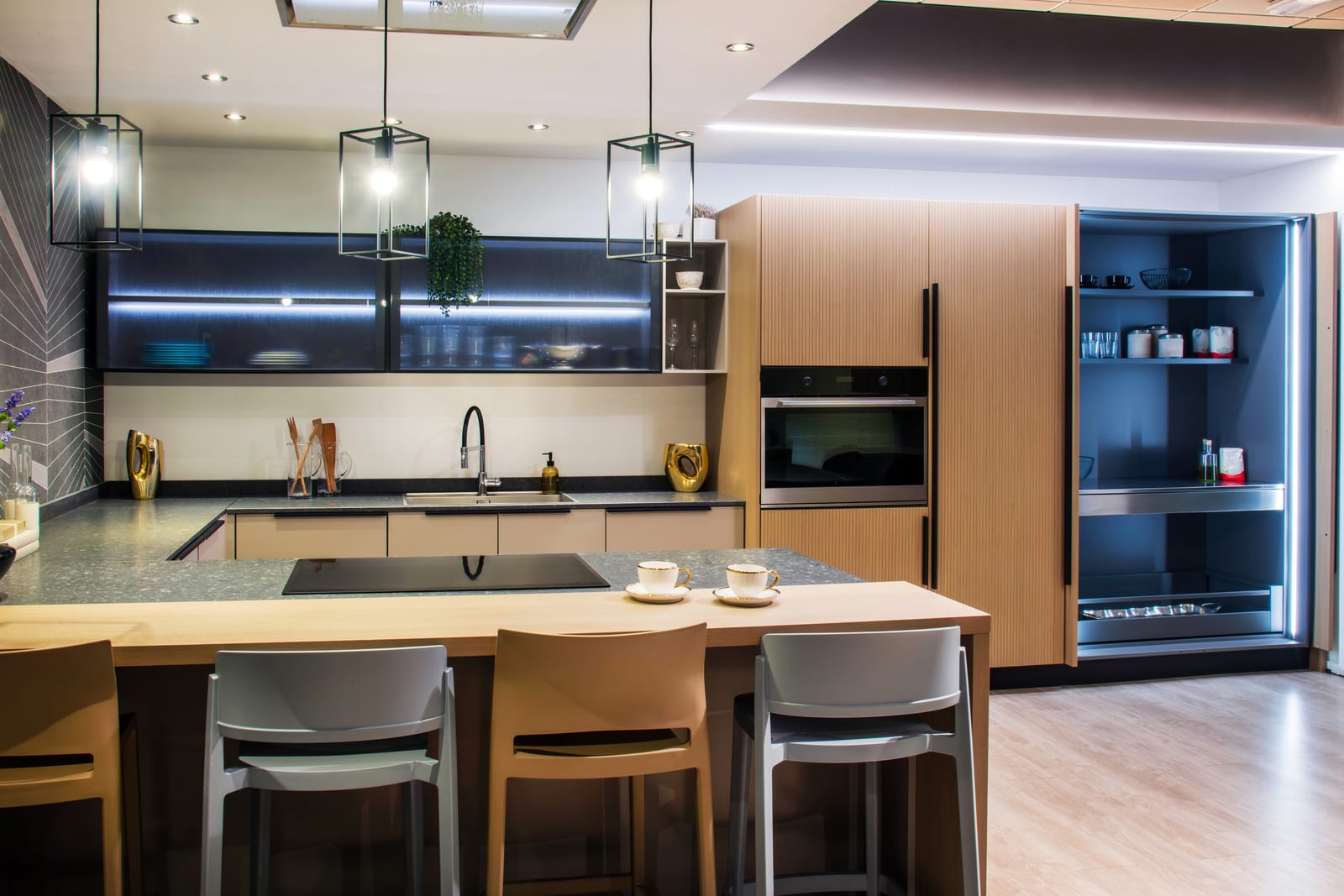 A modern kitchen with an island, feature lighting and integrated appliances
